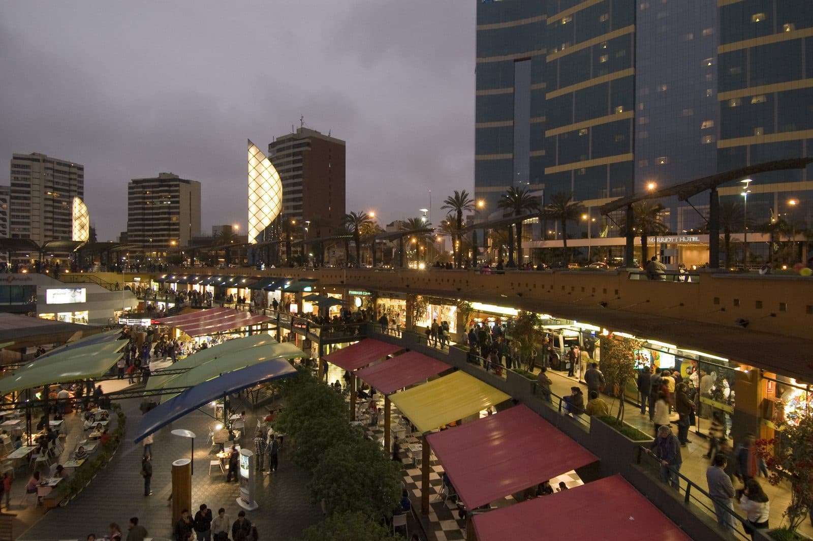 Bustling city market with crowds of people shopping and strolling.