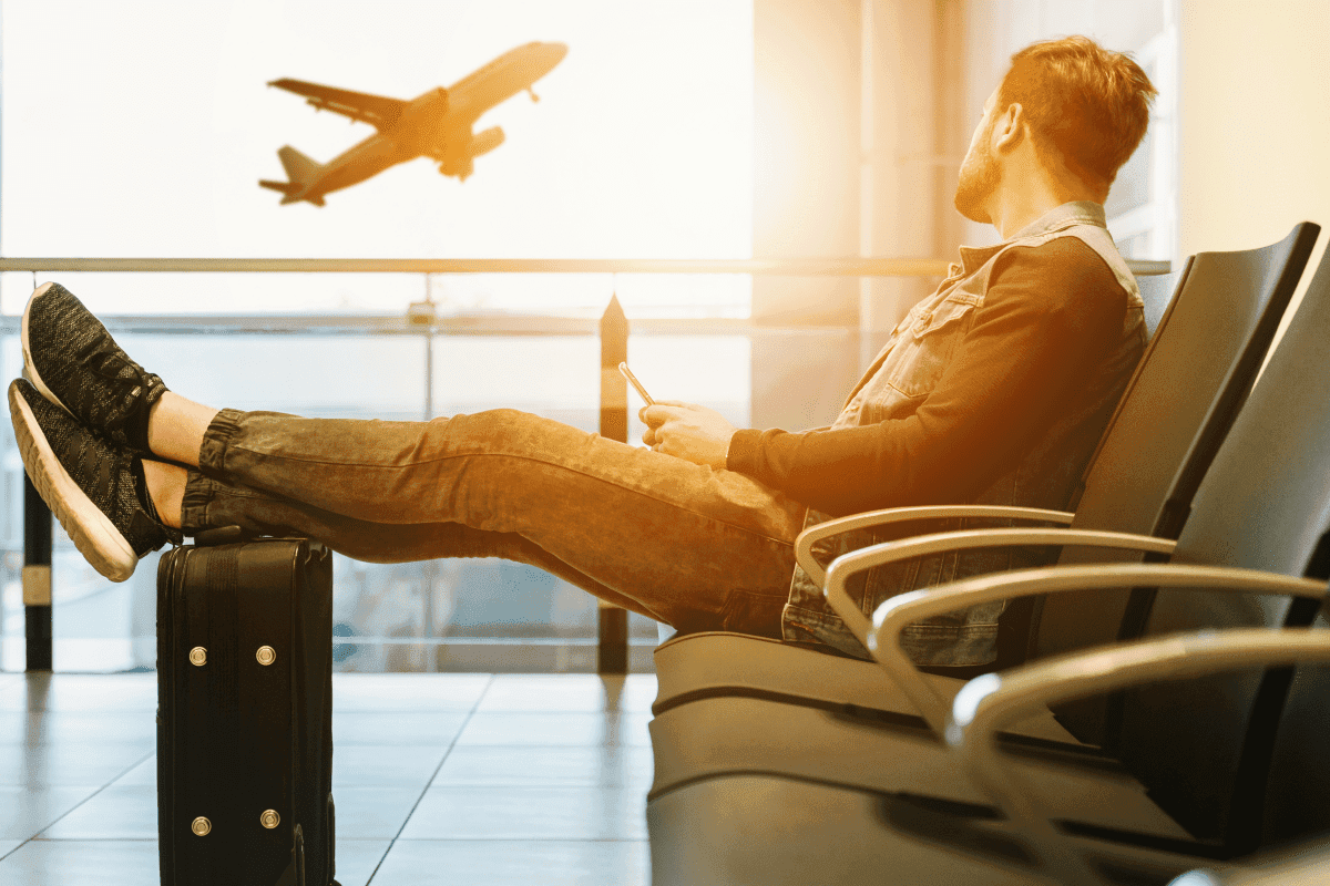 a person sitting in an airport with his feet on his side