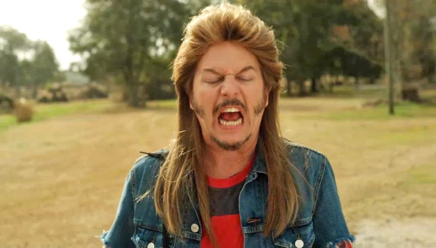 A man with long hair and a mustache looking into the camera.