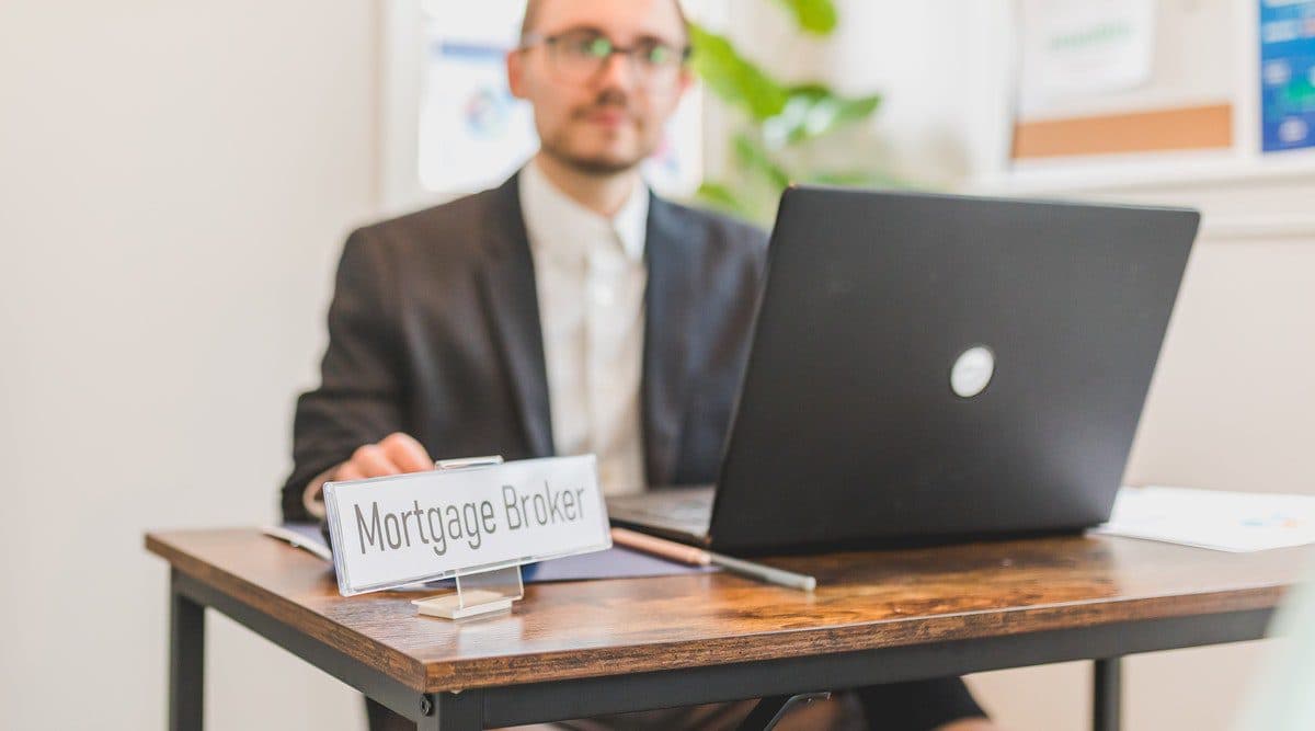 a person sitting at a desk with a sign on it