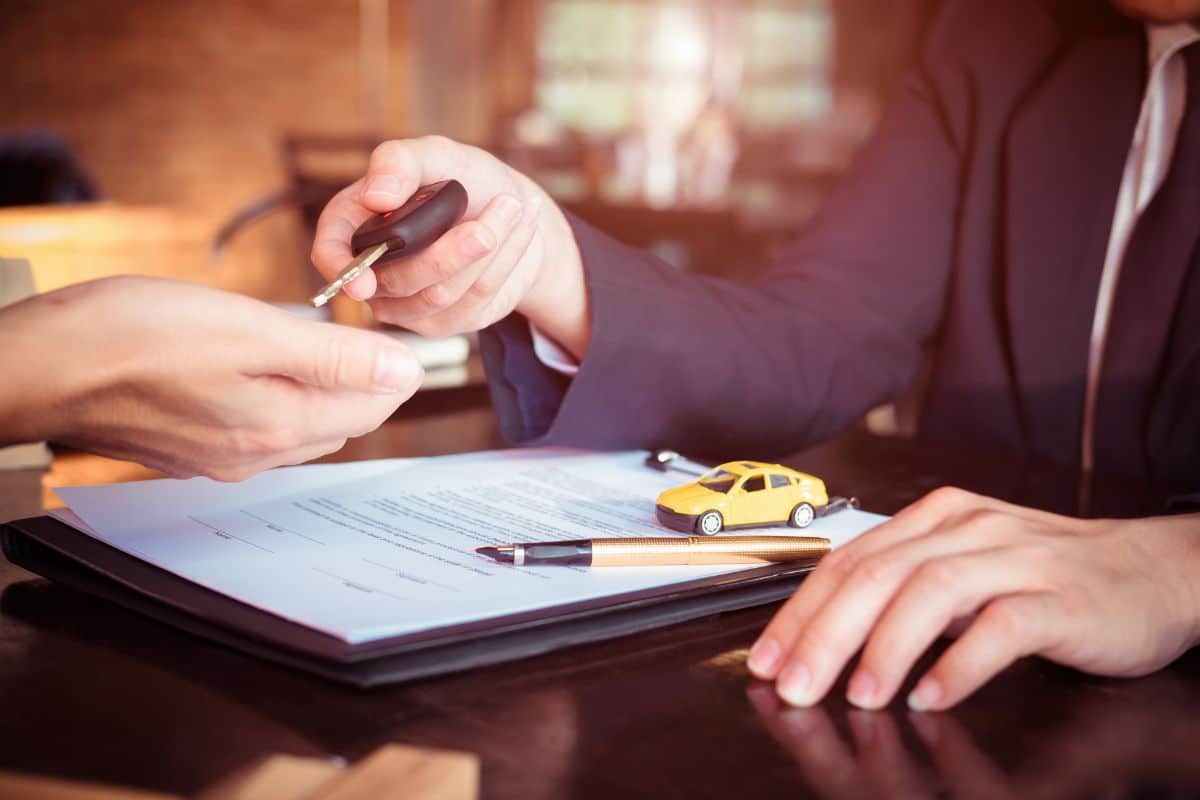 a person handing over a car key