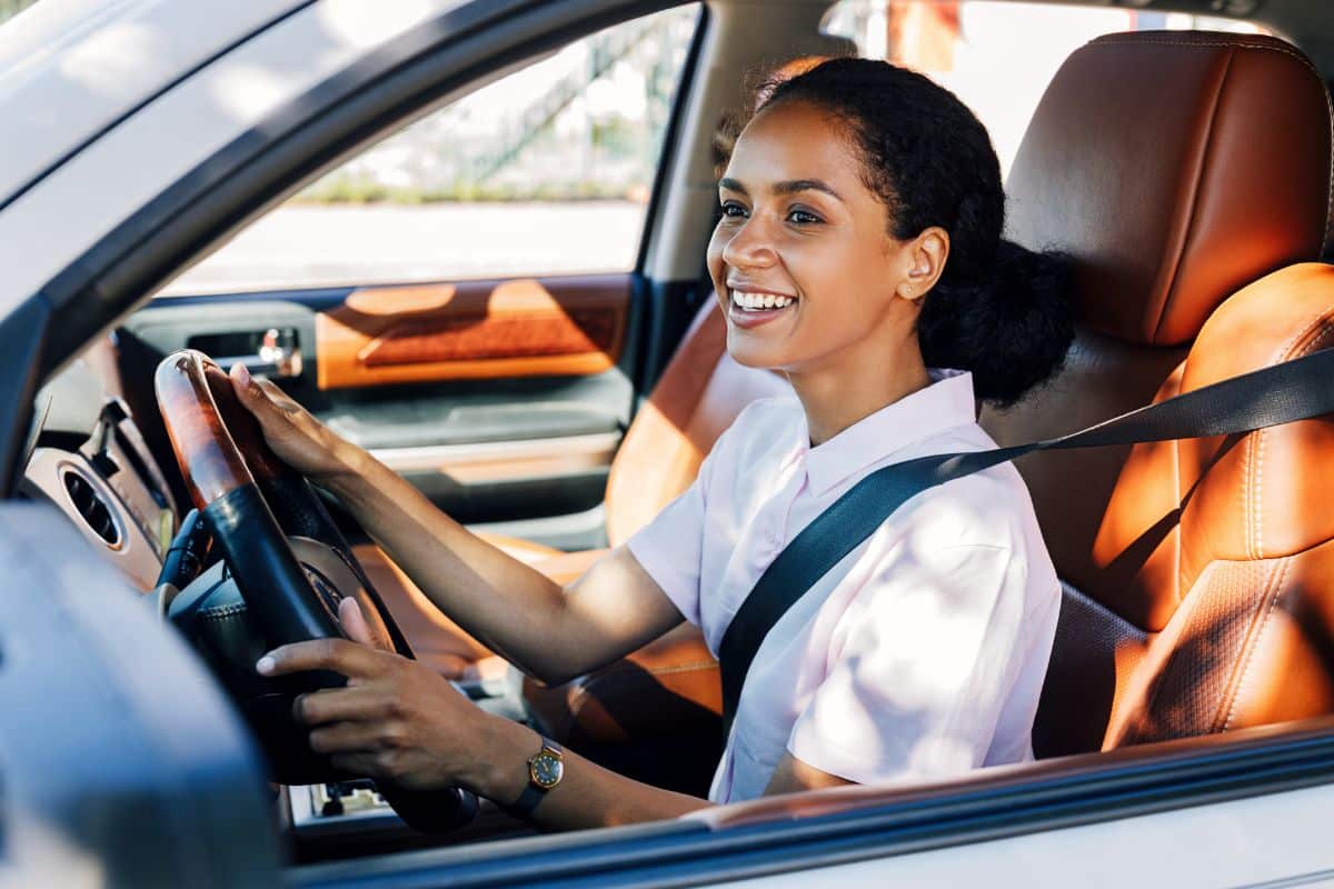 Woman driving car with a smile.