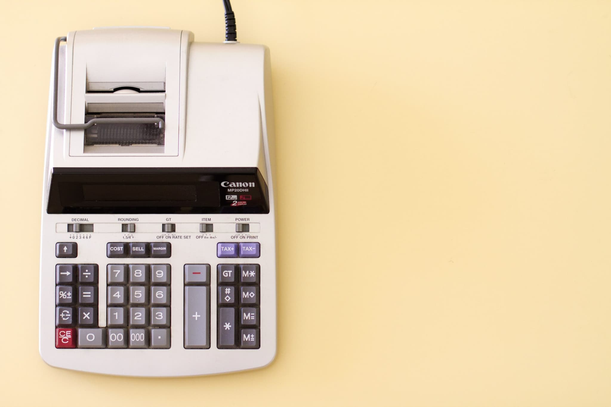 A calculator resting on a vibrant yellow background, ready to perform mathematical and tax calculations efficiently.