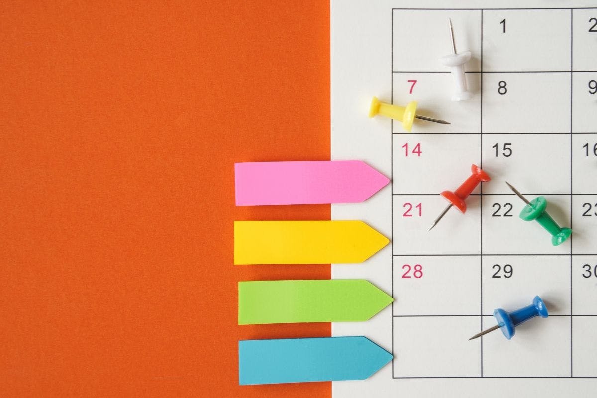 Calendar grid with sticky notes on an orange background