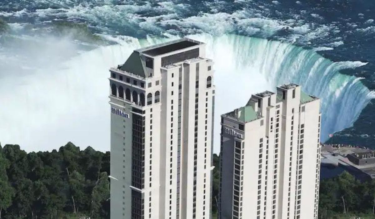 a tall buildings next to a waterfall