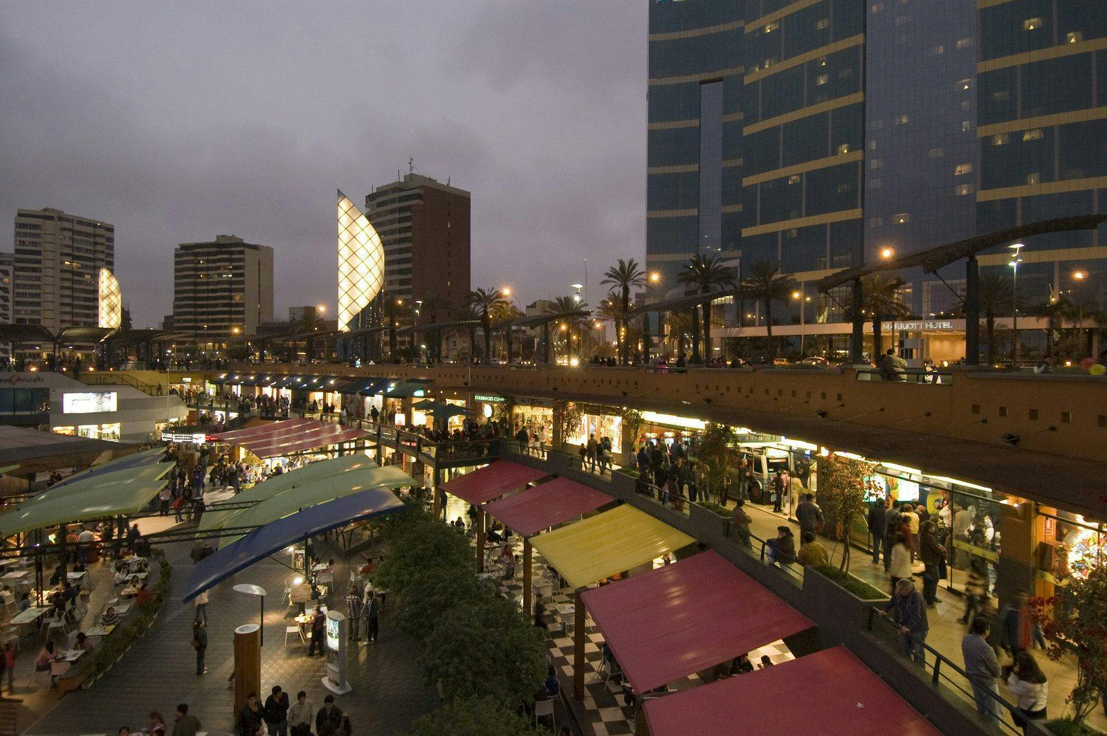 Bustling city market with crowds of people shopping and strolling.