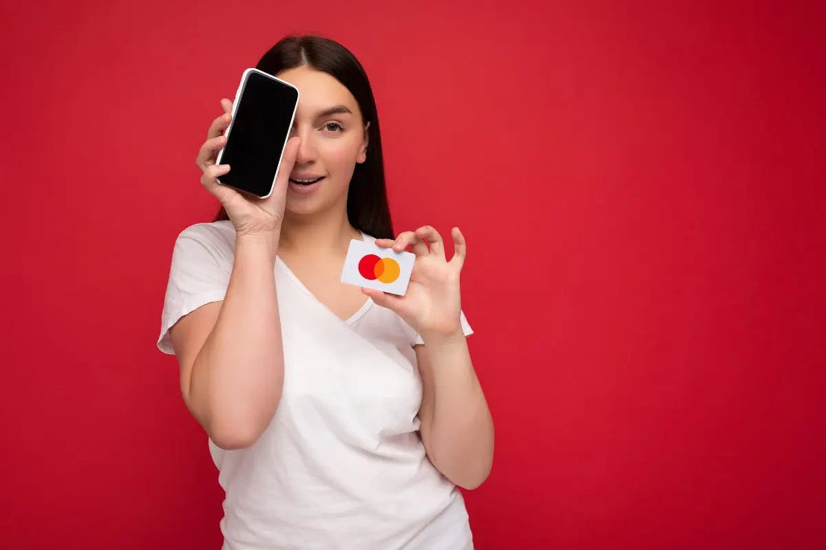 a girl holding a cell phone and a credit card