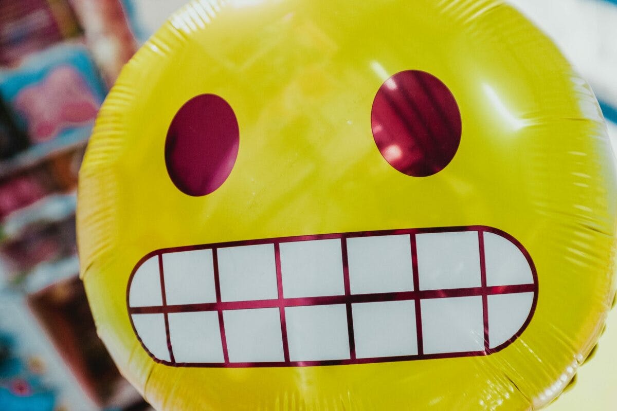 Yellow smiley face balloon with red mouth.
