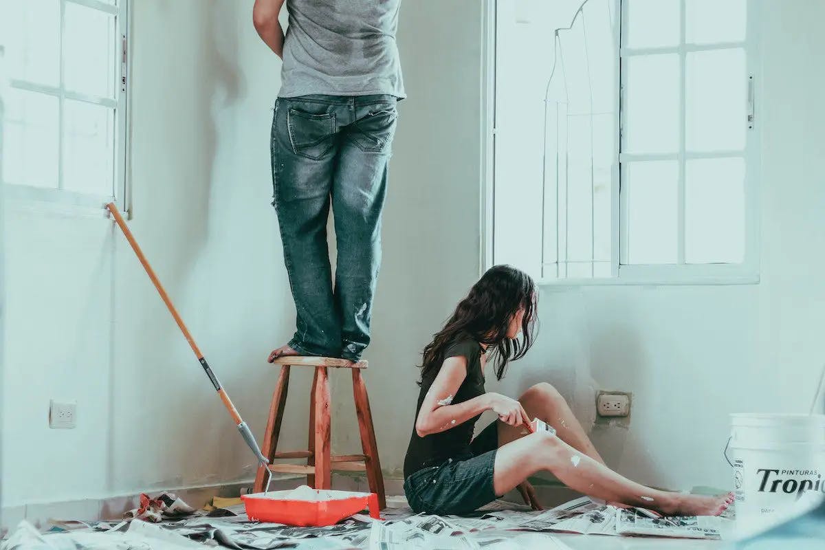 A couple painting a room together, adding color and life to their living space through teamwork and creativity.
