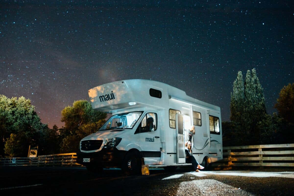 a white camper with a person climbing up the stairs