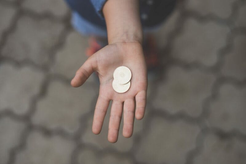 a person holding coins in their hand