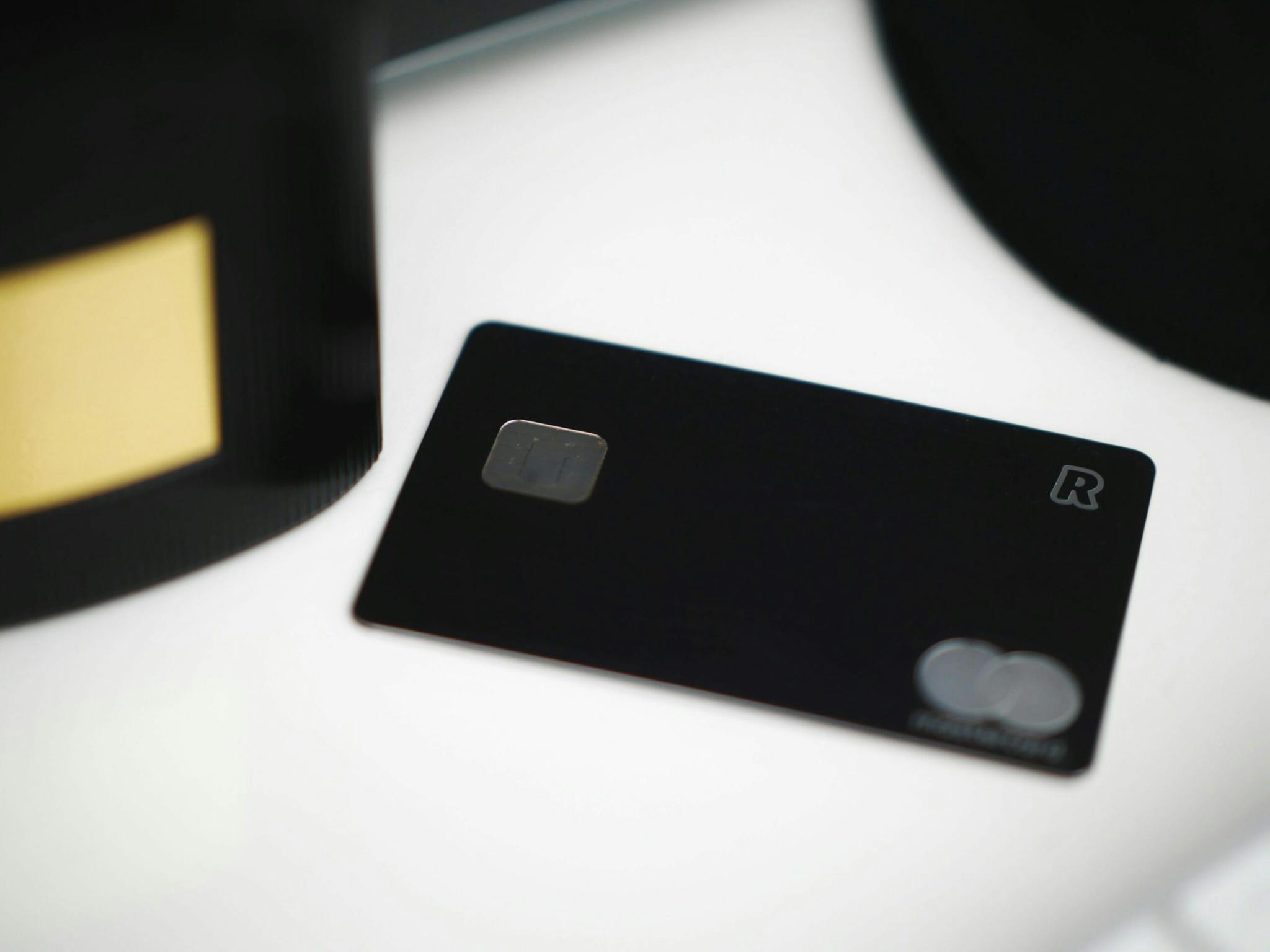 A black credit card resting on a white surface, exuding elegance and sophistication.