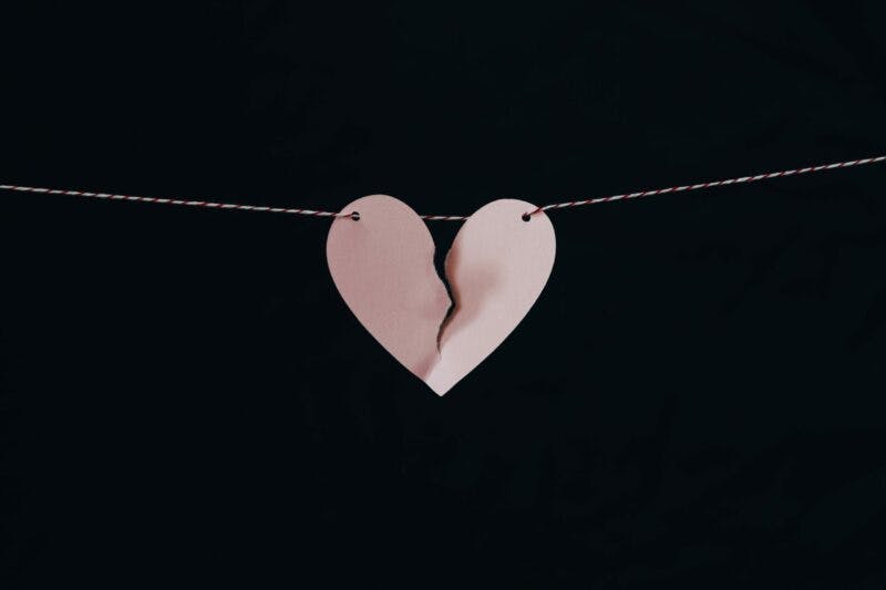 a heart-shaped paper with a broken piece of paper attached to a string