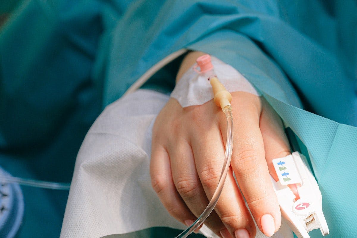 a patient hand holding a iv tube