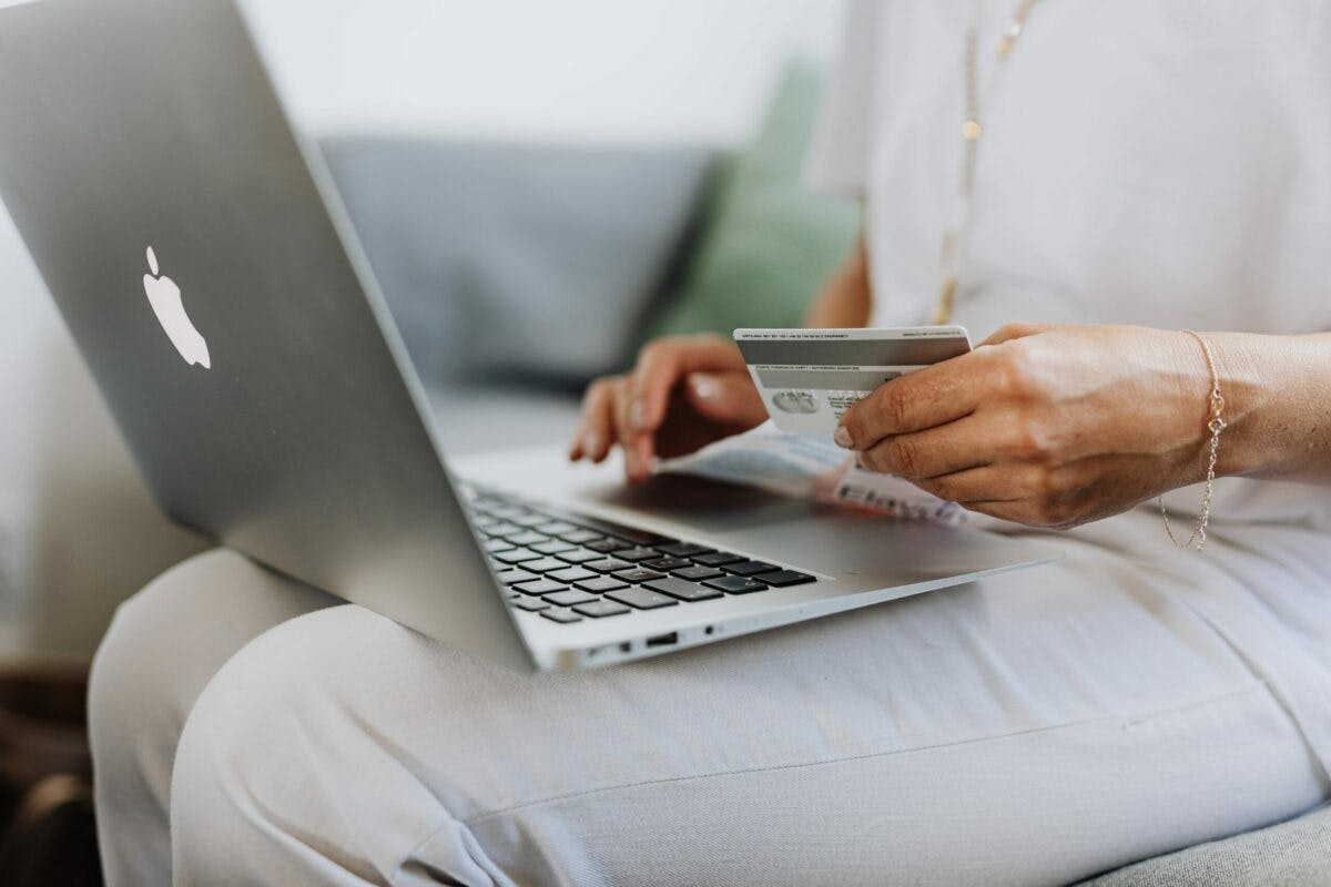 Woman using credit card on laptop.