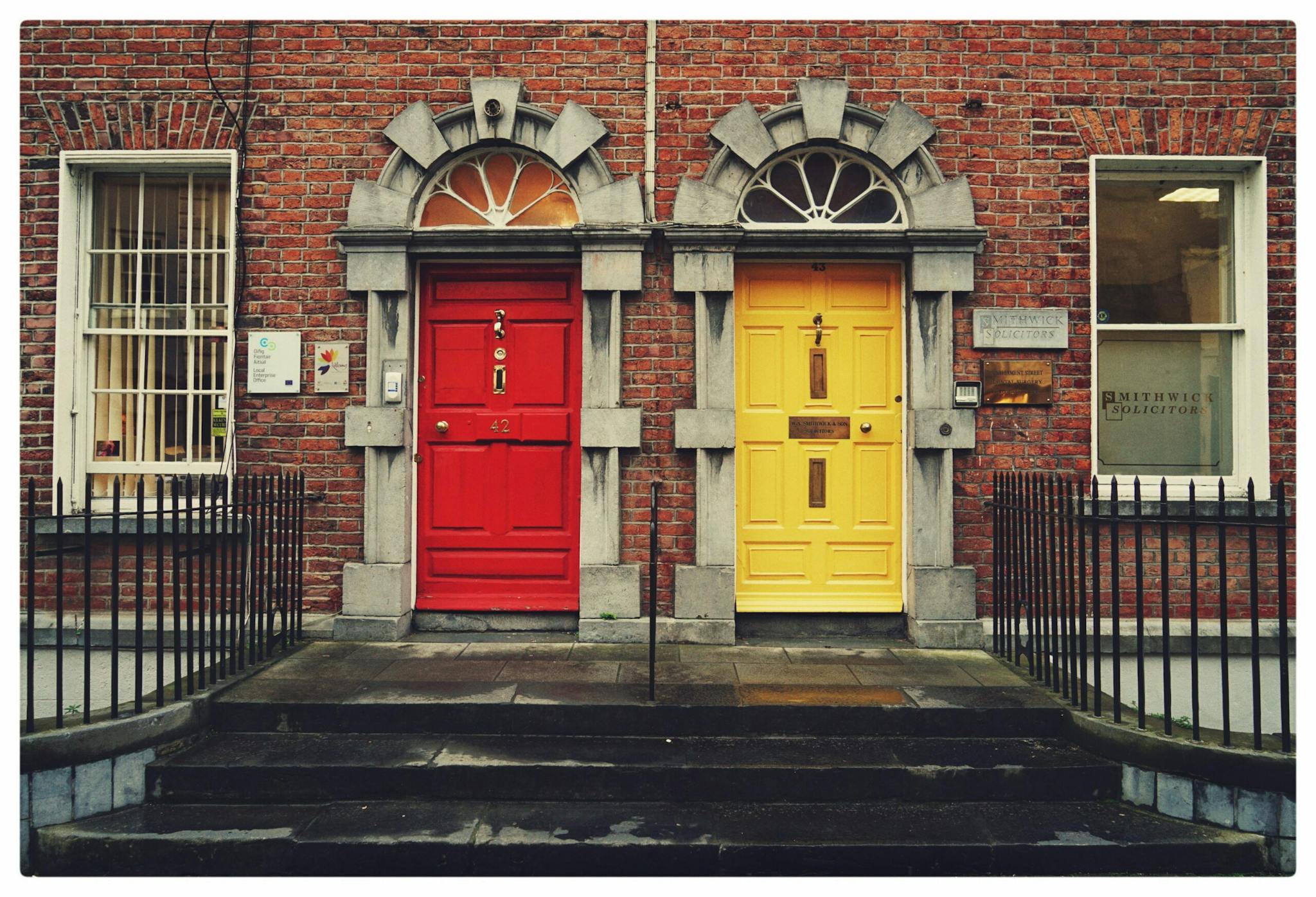 A vibrant pair of doors, one red and one yellow, beckoning with their contrasting hues and promising a world of possibilities beyond.