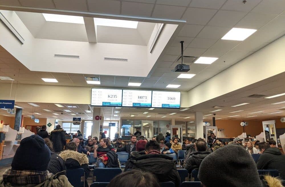 People sitting in chairs at an airport, waiting for their flights.