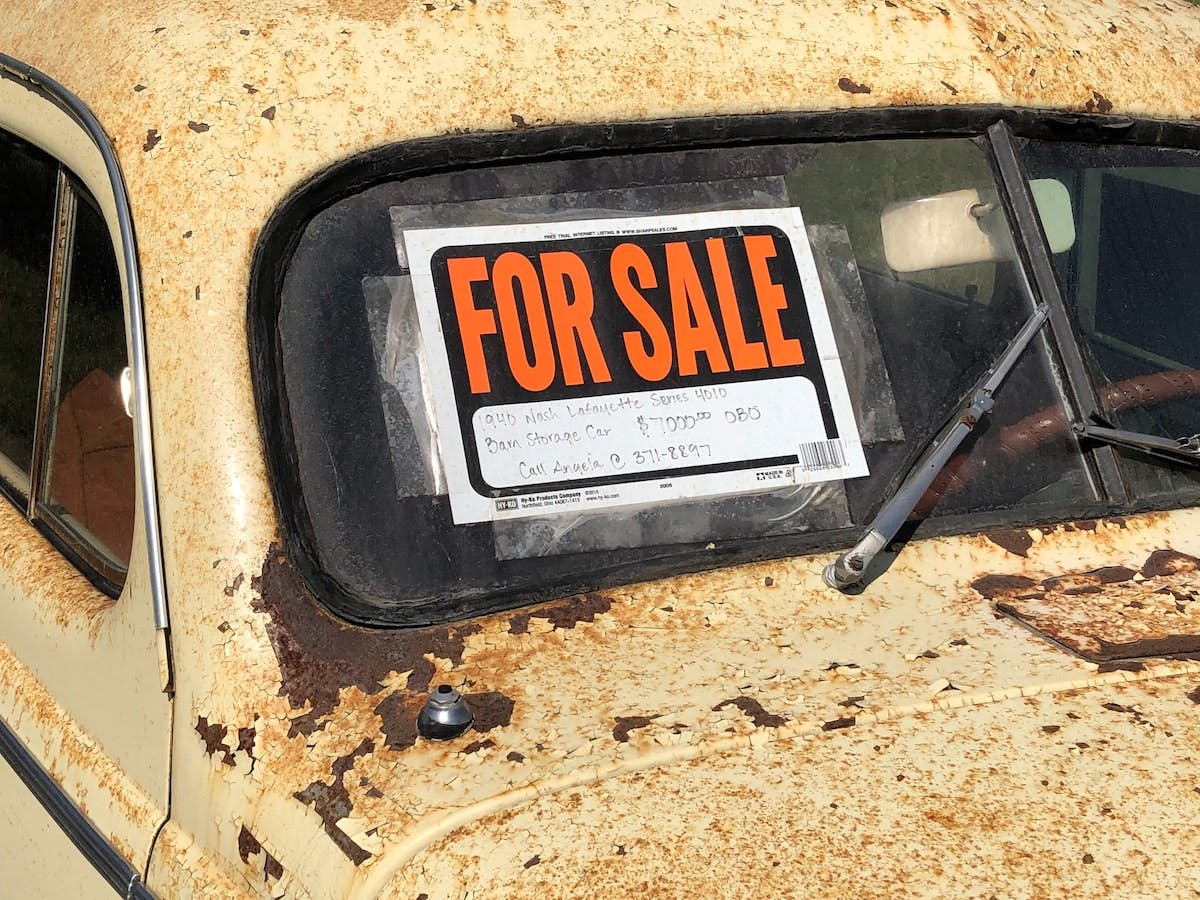 a sign of For Sale on the windshield of a car