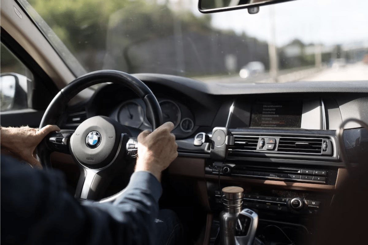 A man holding a BMW car staring