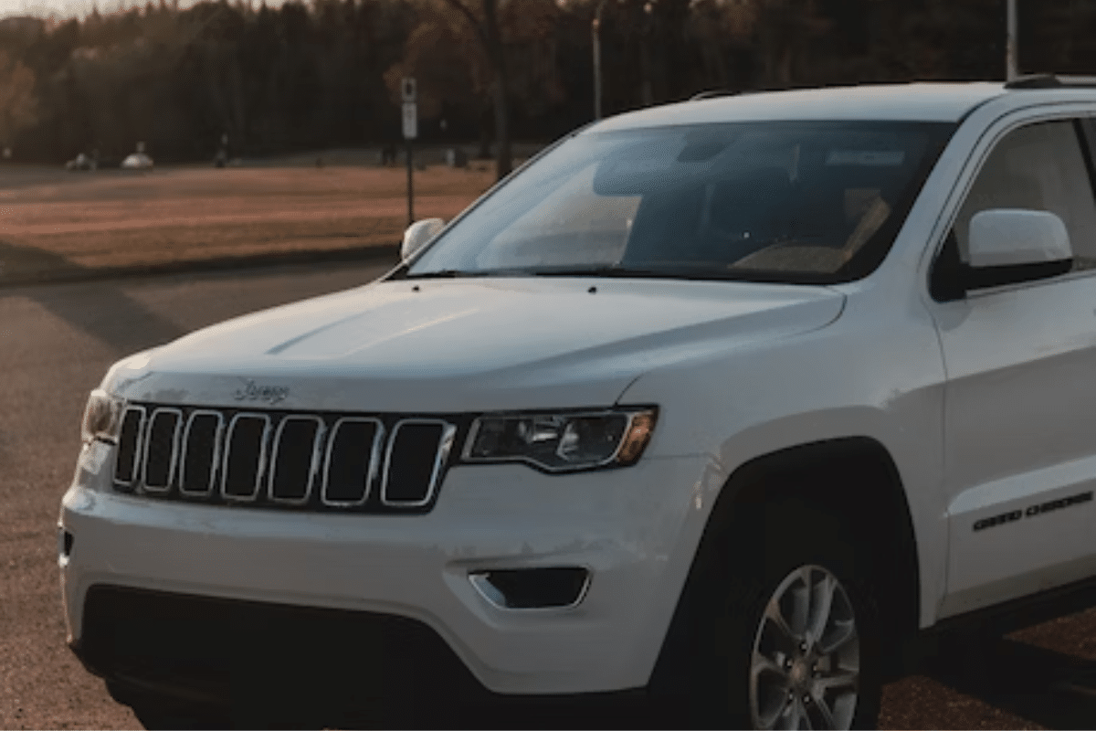 The image depicts a white 2019 Jeep Grand Cherokee