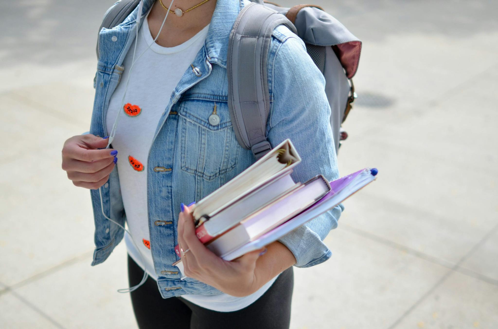 a girl carrying books and a backpack