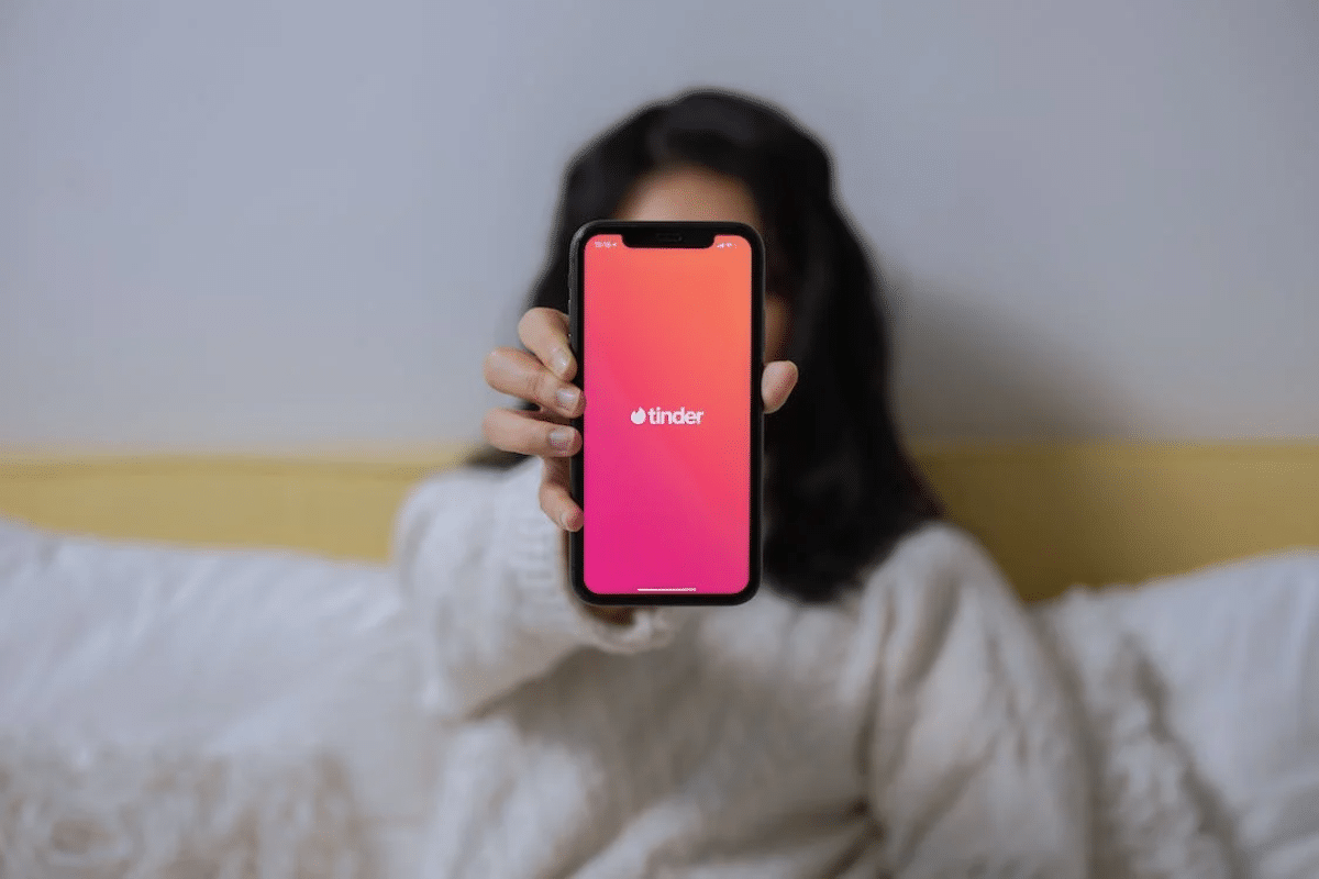 Woman showcasing phone with pink background