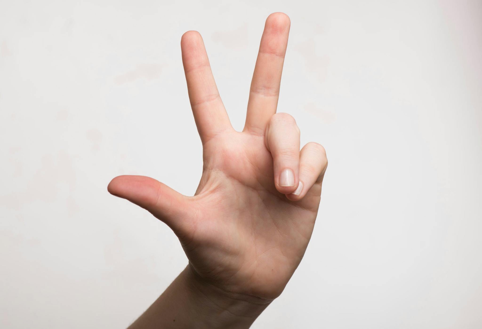 A person displaying the peace sign with their hand, symbolizing harmony and tranquility.