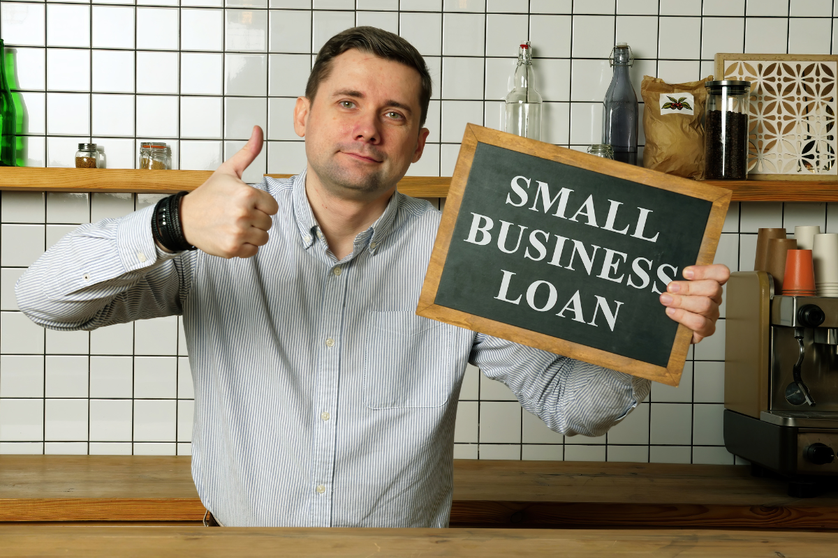 a person holding a small business sign