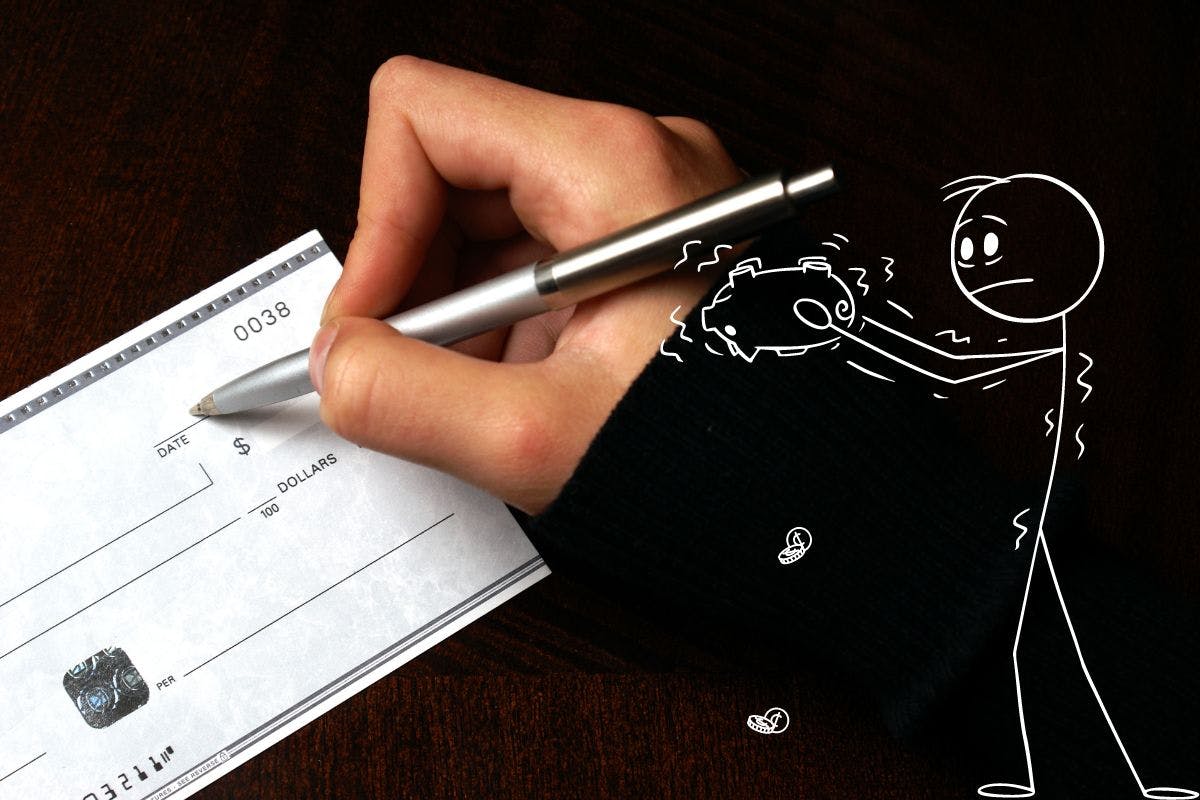 A person writing a check with a pen