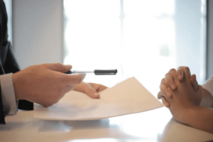 a person holding a pen over a paper